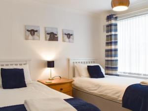 a bedroom with two beds and a window at Little Bere in Lifton