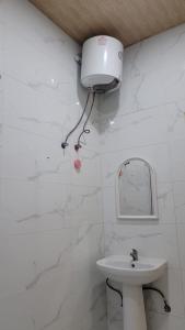 Baño blanco con lavabo y espejo en فلل فندقية بمدينة تنومة en Ithnayn
