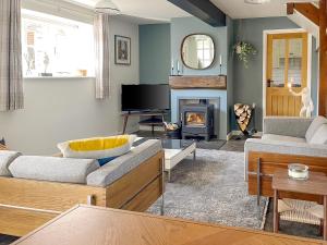 a living room with two couches and a fireplace at Honey Bee Cottage in Calbourne