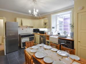 uma cozinha com uma mesa com pratos em Rennie House em East Linton
