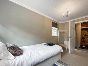 um quarto com uma cama com lençóis brancos em Rennie House em East Linton