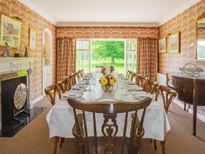 a dining room with a long table and a fireplace at Glanusk Lodge - Uk46654 in Crickhowell
