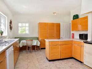a kitchen with wooden cabinets and a table in it at Glanusk Lodge - Uk46654 in Crickhowell