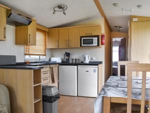 a kitchen with white appliances and wooden cabinets at Swift Johnson in Dovercourt