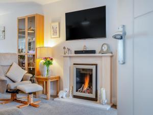 a living room with a fireplace with a tv above it at Riverview in Market Deeping