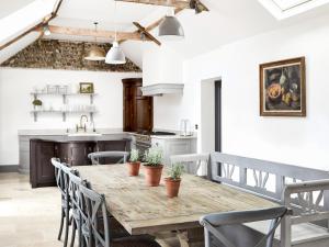 a kitchen and dining room with a wooden table and chairs at Eden Hall Cottage in Bacton