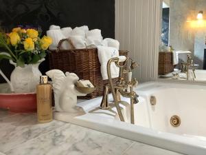 a bathroom with a sink and a bath tub with towels at WestLaigh Lrg Luxury Country Farm House 20 min from the city in Glassford