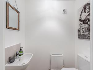 a white bathroom with a sink and a mirror at Haras House in Tiverton