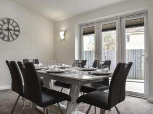 a dining room with a table and chairs and a clock at Gadebridge in Thornaby on Tees