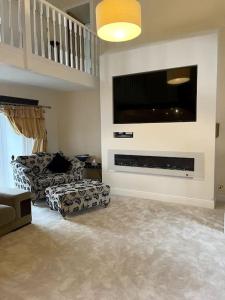 a living room with a large flat screen tv on the wall at Lrg Luxury Country Farm House 20 min from the city in Glassford