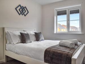 a white bedroom with a large bed with a window at Gadebridge in Thornaby on Tees
