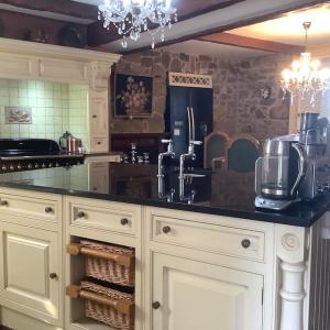 a kitchen with white cabinets and a black counter top at WestLaigh Lrg Luxury Country Farm House 20 min from the city in Glassford