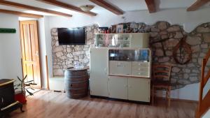 a room with a refrigerator and a stone wall at Kuća - Krčina in Cres