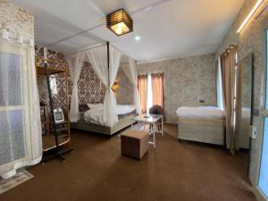 a bedroom with two beds with curtains and a table at The Rare Ones - Resorts, Cafe & Game Zone in Mukteshwar