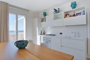 uma cozinha com armários brancos e uma mesa de madeira em Ferienwohnung für 5 Personen ca 110 qm in Cefalù, Sizilien Nordküste von Sizilien em Cefalù