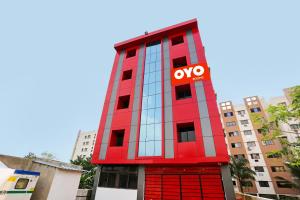 a red building with a yes sign on it at Capital O Hotel Aryan in Khandagiri