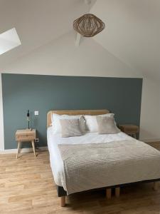 una camera con un letto con una parete blu di Ducey Appart'Hôtel - Les Rivières a Ducey