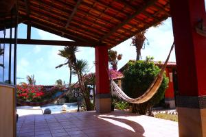 een veranda met een hangmat in een resort bij Pousada Villa Flamboyant in Beberibe