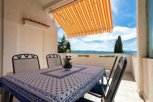 een blauwe en witte tafel en stoelen op een balkon bij Ferienwohnung für 4 Personen ca 60 qm in Njivice, Kvarner Bucht Krk in Njivice