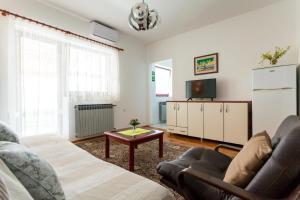 een woonkamer met een bank en een tv bij Ferienwohnung für 4 Personen ca 60 qm in Njivice, Kvarner Bucht Krk in Njivice