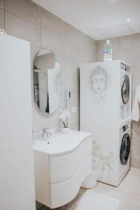 Baño blanco con lavabo y espejo en Splendide appartement Cosy en Brioude