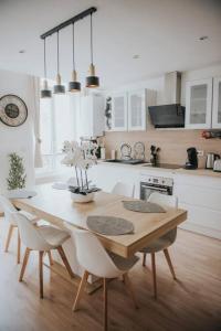 a kitchen with a wooden table with chairs and a dining room at Splendide appartement Cosy in Brioude