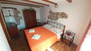 1 dormitorio con 1 cama y 1 cruz en la pared en Kuća - Krčina, en Cres
