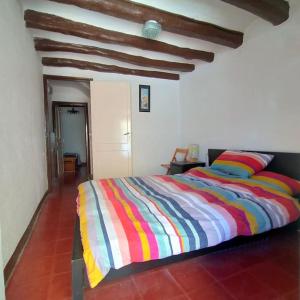 - une chambre avec un lit et une couette colorée à rayures dans l'établissement Traditional Spanish Town House, à Móra d'Ebre