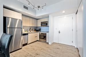 a kitchen with a stainless steel refrigerator and white cabinets at Ocean Views - Pool & Gym - Pet Friendly - Close to Beach in Hallandale Beach