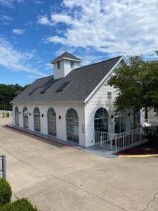 a white building with a gambrel roof at Carriage House Inn in Branson