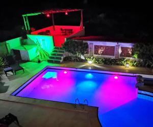 a swimming pool lit up at night at Pousada Villa Flamboyant in Beberibe