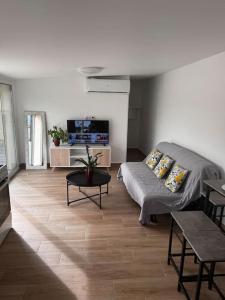 un soggiorno con un divano e un tavolo di Maison entièrement Neuve a Marsiglia