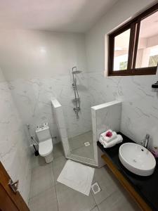 La salle de bains est pourvue d'une douche, de toilettes et d'un lavabo. dans l'établissement YU Resort, à Msambweni