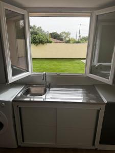 una cucina con un lavandino e una finestra di Maison entièrement Neuve a Marsiglia