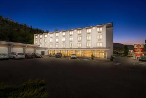 Best Western Plus Columbia River Hotel في Trail: مبنى كبير به سيارات تقف في موقف للسيارات