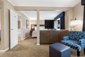 Habitación de hotel con sofá, TV y cama en Best Western Plus Columbia River Hotel, en Trail