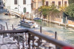 ein Boot in einem Kanal mit einer Brücke und Gebäuden in der Unterkunft Studio für 8 Personen ca 150 qm in Venedig, Adriaküste Italien Venedig und Umgebung in Venedig