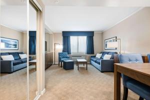 Best Western Plus Columbia River Hotel في Trail: غرفة معيشة مع أريكة زرقاء وطاولة