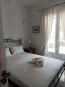- une chambre avec un grand lit blanc et une fenêtre dans l'établissement Koundouros Petra house, à Koundouros
