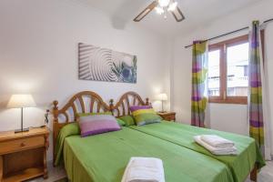 a bedroom with a green bed and a window at Appartement in Son Baulo mit Grill in Can Picafort