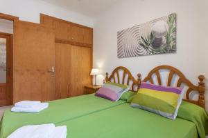 a bedroom with two beds with green sheets at Appartement in Son Baulo mit Grill in Can Picafort