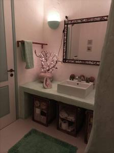 La salle de bains est pourvue d'un lavabo et d'un miroir. dans l'établissement Koundouros Petra house, à Koundouros