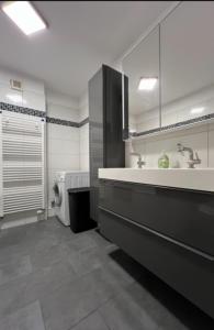 La salle de bains est pourvue d'un lavabo et d'un lave-linge. dans l'établissement Privatzimmer Langenhagen nahe Flughafen Hannover, à Langenhagen