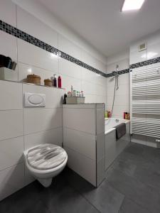 La salle de bains blanche est pourvue de toilettes et d'une baignoire. dans l'établissement Privatzimmer Langenhagen nahe Flughafen Hannover, à Langenhagen