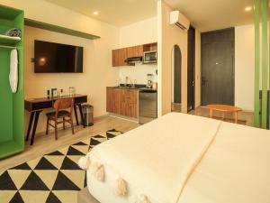 a bedroom with a large bed and a kitchen at Tribu Sonata with pool in Guadalajara