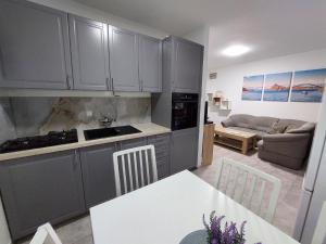 eine Küche mit grauen Schränken und ein Wohnzimmer in der Unterkunft Studio für 5 Personen ca 45 qm in Njivice, Kvarner Bucht Krk in Njivice