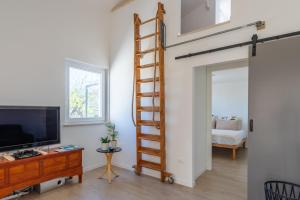 een woonkamer met een hoogslaper en een televisie bij Residenza Verdeoliva - YourPlace Abruzzo in Rocca San Giovanni