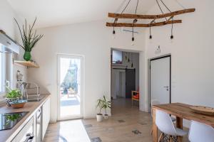 cocina y comedor con mesa de madera en Residenza Verdeoliva - YourPlace Abruzzo, en Rocca San Giovanni