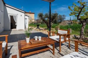 un patio con mesa, sillas y sombrilla en Residenza Verdeoliva - YourPlace Abruzzo, en Rocca San Giovanni