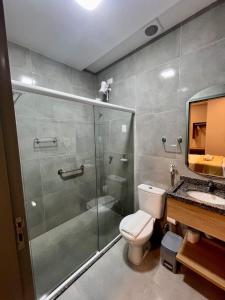 a bathroom with a shower and a toilet and a sink at Hotel Place Jardin in Garanhuns